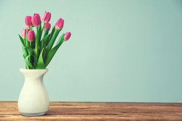 Vase with beautiful tulips on wooden table