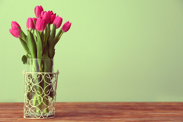 Vase with beautiful tulips on wooden table