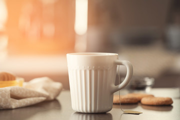 Cup with delicious tea on table