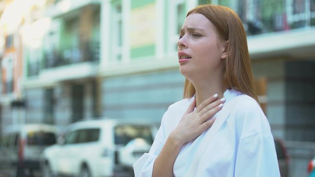 Teenage girl starting to cough trying to inhale, contaminated air, pollution