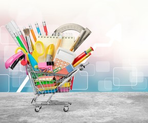 Colorful school supplies in shopping cart