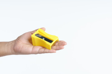 Hand holding big pencil sharpener for peeling carrot