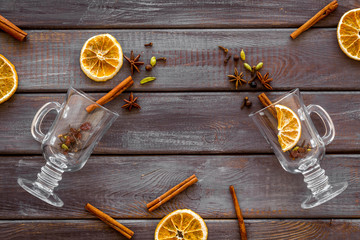 New Year beverage. Ingredients for mulled wine in glasses on dark wooden background top view copy...