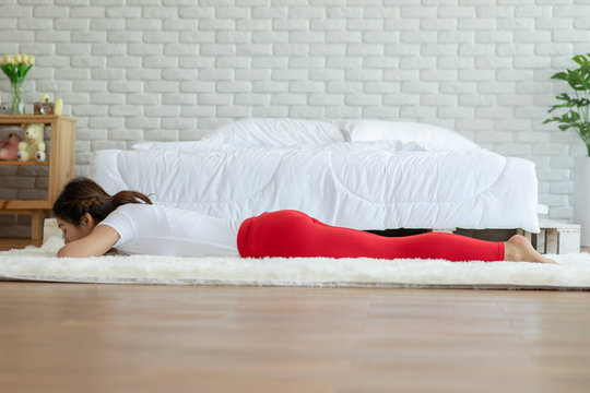 Athletic Asian woman practice yoga yoga crocodile pose or Makarasana Pose to meditation in bedroom after wake up in the morning Feeling so comfortable and relax,Healthcare Concept