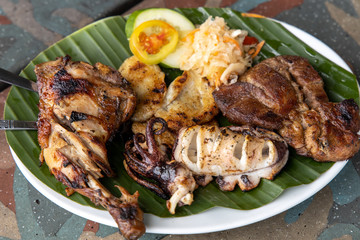 Pork, Squid, Chicken, Fish Filipino Barbecue on the Banana leaf plate
