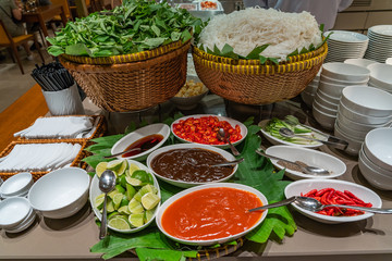 Traditional Vietnamese Pho noodle soup and seasoning in buffet counter