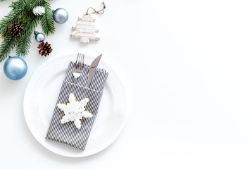 Table setting for new year with pine branch, decorations, plate and tableware white background top view copyspace