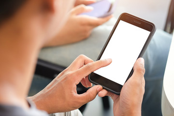 Cropped shot view of man hands holding smart phone with blank copy space screen for your text message or information content, female reading text message on cell telephone during in urban setting. 