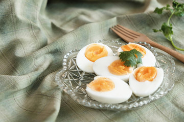 Boiled eggs cut in half, placed in a red bowl, on the tablecloth