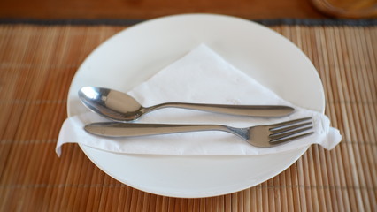 plate with knife and fork on wooden table