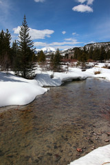 Colorado snowy early spring beautiful nature background. Scenic view with water stream on a covered by snow valley between rocky mountains. Amazing Keystone landscape, Colorado, USA.