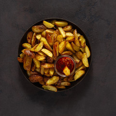 Fried potatoes with  brava sauce on a dark background with copy space top view