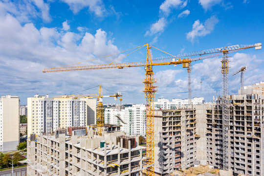 tower cranes working at construction site in city residential area. birds eye view panoramic image