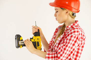 Woman wearing helmet using drill