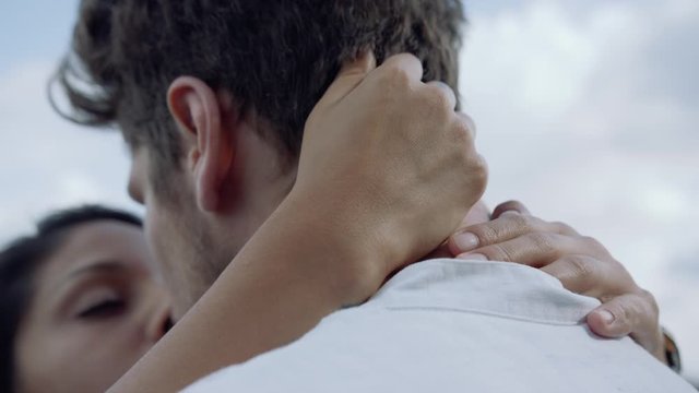 Close up of a young woman's hands caressing her boyfriend's hair.