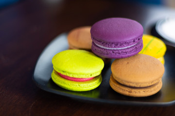 French Colorful Macarons Colorful Pastel Macarons on black plate.