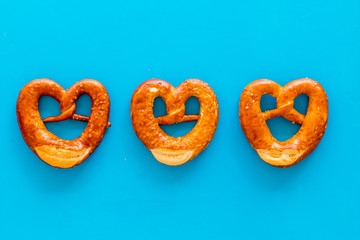 Octoberfest symbol. Fresh bavarian pretzels on blue background top view