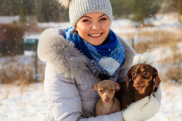 Woman playing with dogs during winter