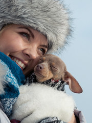 Woman hug warming her dog in cold day