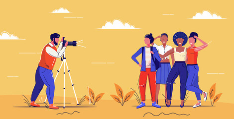 Obraz premium professional male photographer using digital dslr camera on tripod shooting mix race girls posing together for photo fashion shoot concept full length horizontal sketch