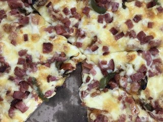 Delicious cheese pizza with ham and green peppers