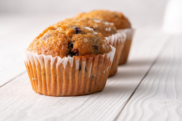 Blueberry muffins with white table place setting.