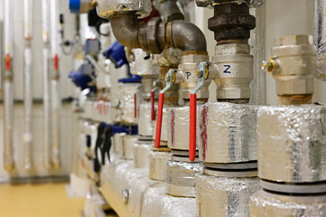 Rotary levers of ball valves on water pipeline with thermal aluminum cover.