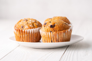 Blueberry muffins with white table place setting.