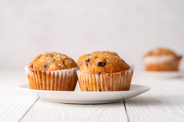 Blueberry muffins with white table place setting.