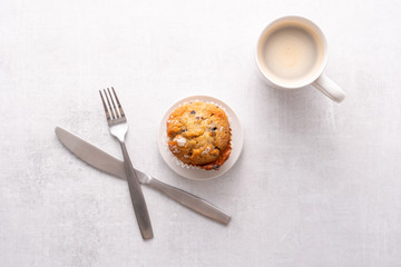 Blueberry muffins with white table place setting.
