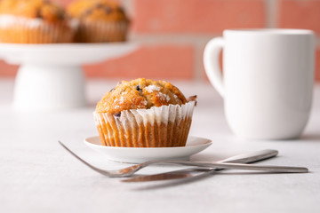 Blueberry muffins with white table place setting.