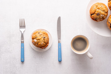 Blueberry muffins with white table place setting.