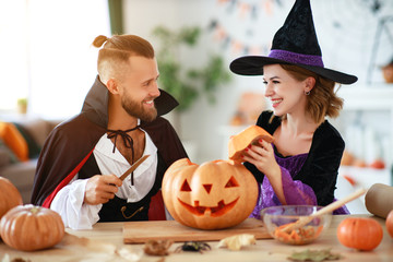 couple of people are preparing for Halloween in costumes of witch and vampire with pumpkins.