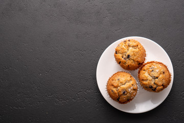 Blueberry muffins with black table place setting.