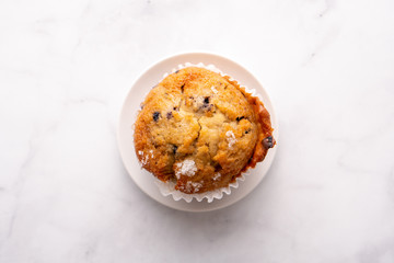 Blueberry muffins with white table place setting.