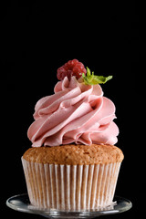 The process of making cupcakes, coating a cream from a pastry bag in the hands of a pastry chef.