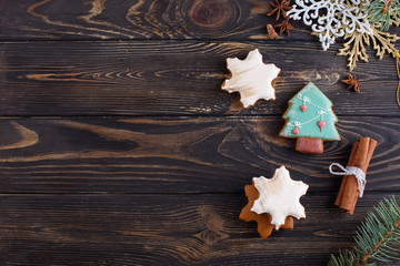 Christmas gingerbread cookies on a wooden background with aromatic coffee and cinnamon sticks