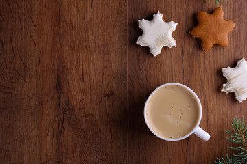 Christmas gingerbread cookies on a wooden background with aromatic coffee and cinnamon sticks