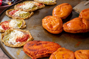 Comida mexicana: comal con sopes con queso y salsa picante, más pambazos. Son antojitos, usualmente comida callejera