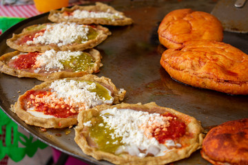 Comida mexicana: comal con sopes con queso y salsa picante, más pambazos. Son antojitos, usualmente comida callejera