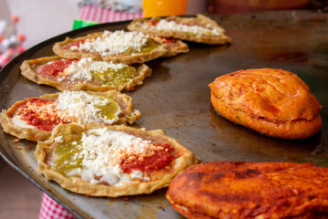 Comida mexicana: comal con sopes con queso y salsa picante, más pambazos. Son antojitos, usualmente comida callejera