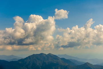 The mountains and forests with blue sky and white clouds at the peak of Inthanon national park (park name) in Chiang Mai province , Thailand in a cloudy and sunny day.