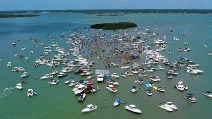 Aerial view of boats surrounding annual sand bar party near John's Pass Boardwalk located in Madeira Beach, Florida.