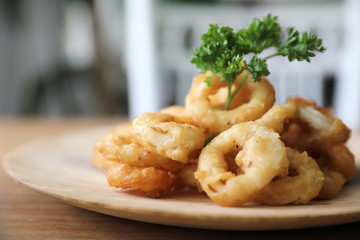 Caramari , Appetizer Crispy fried squid ring with tartar sauce on wood background traditional italian food