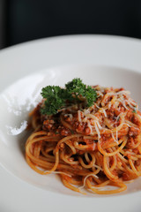 spaghetti Bolognese with minced beef and tomato sauce garnished with parmesan cheese and basil , Italian food