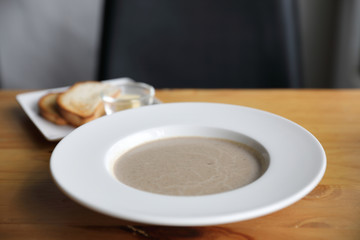 Apptetizer mushroom soup with bread on wood background