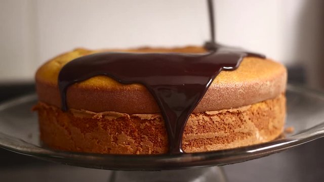 Chocolate icing on carrot cake. Chocolate glaze pouring on homemade cake. Brazilian carrot cake. Topping chocolate on carrot cake. June Partys sweet