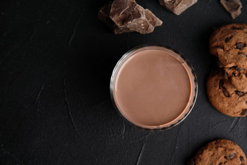 Flat lay composition with glass of tasty chocolate milk and space for text on dark background. Dairy drink