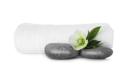 Towel, fresh flower and spa stones isolated on white