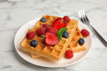 Naklejka na ściany i meble Delicious waffles with fresh berries served on white marble table